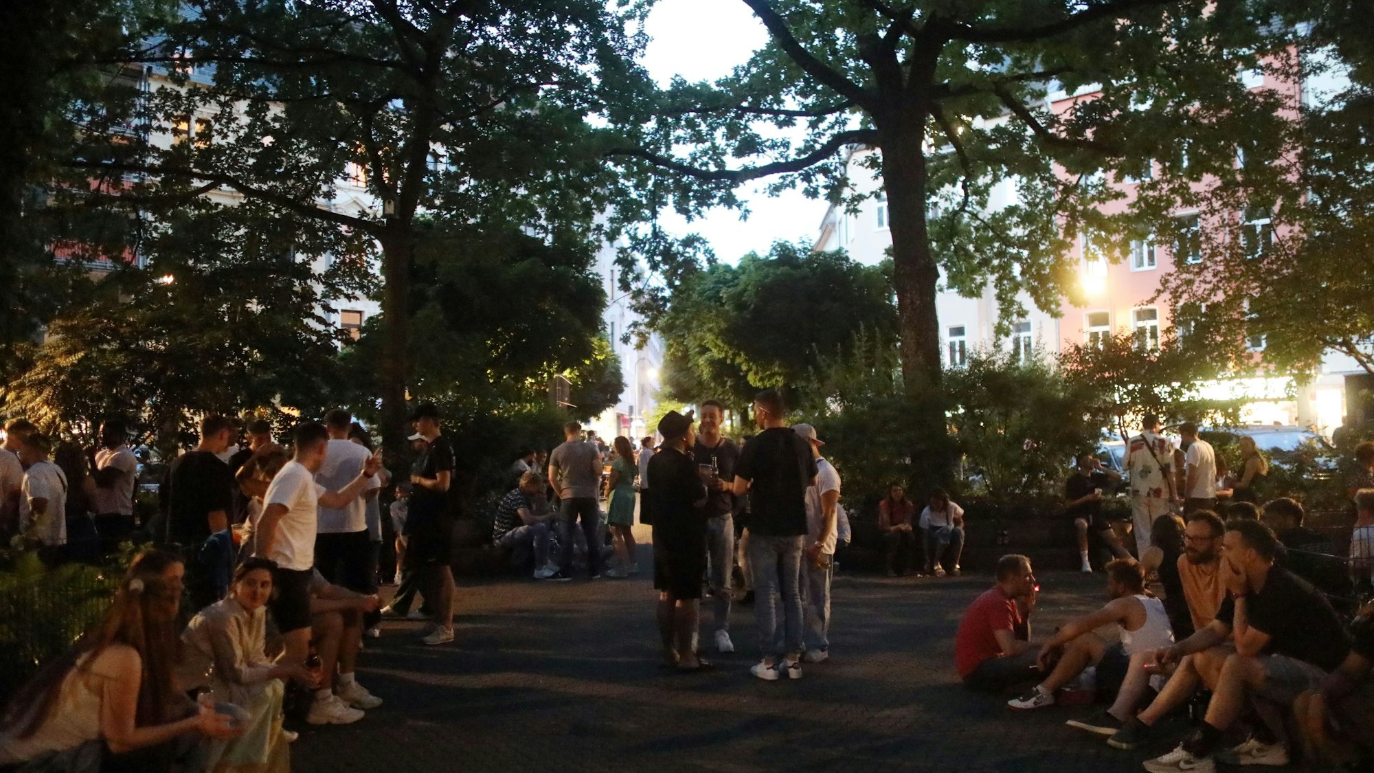 Eine warme Nacht am Brüsseler Platz. Menschen genießen den Frühsommer und verabreden sich.