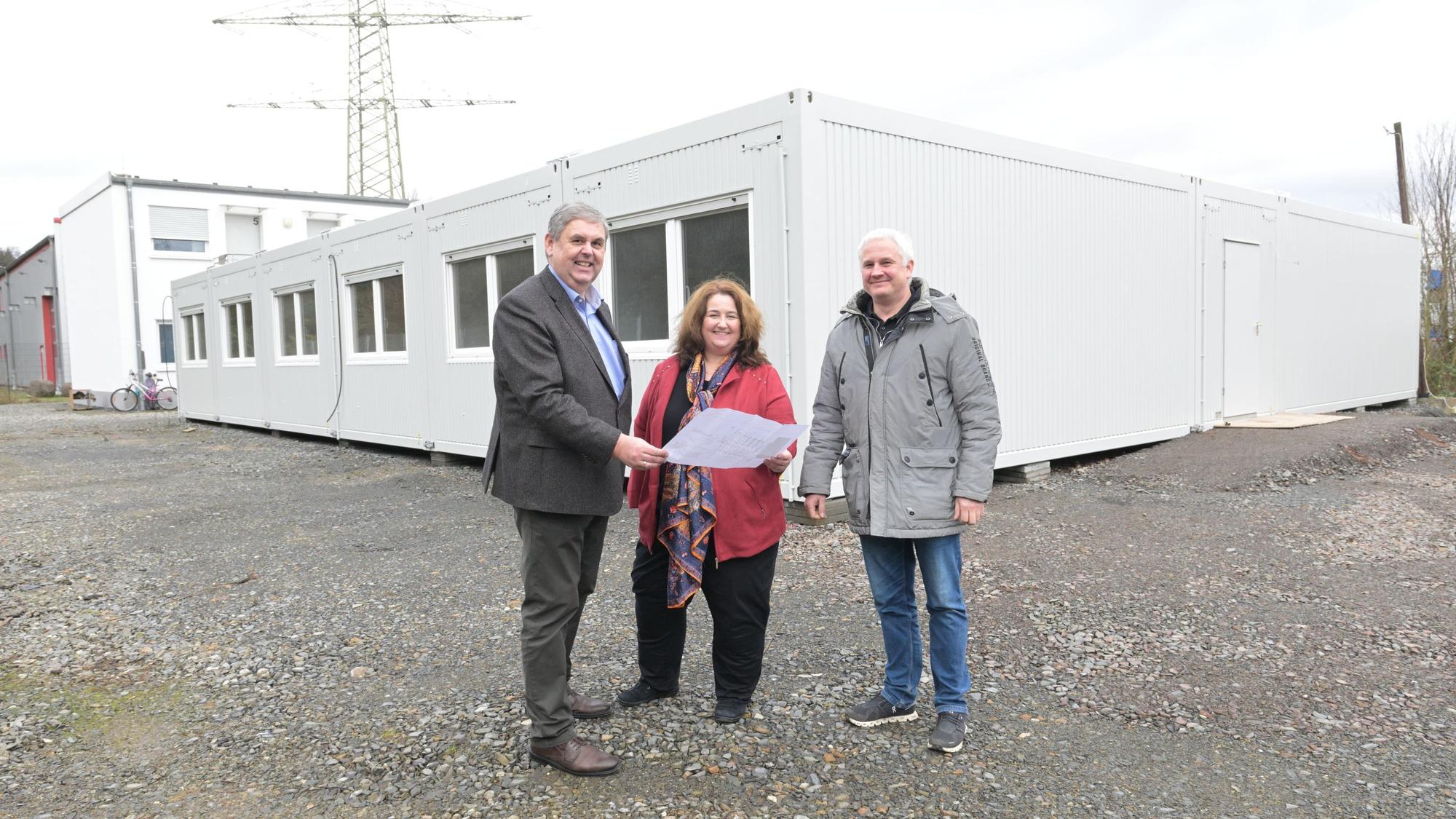 Bondina Schulze, Ulrich Kowalewski und Christian Thönelt stehen vor einer Asylunterkunft in Rösrath.
