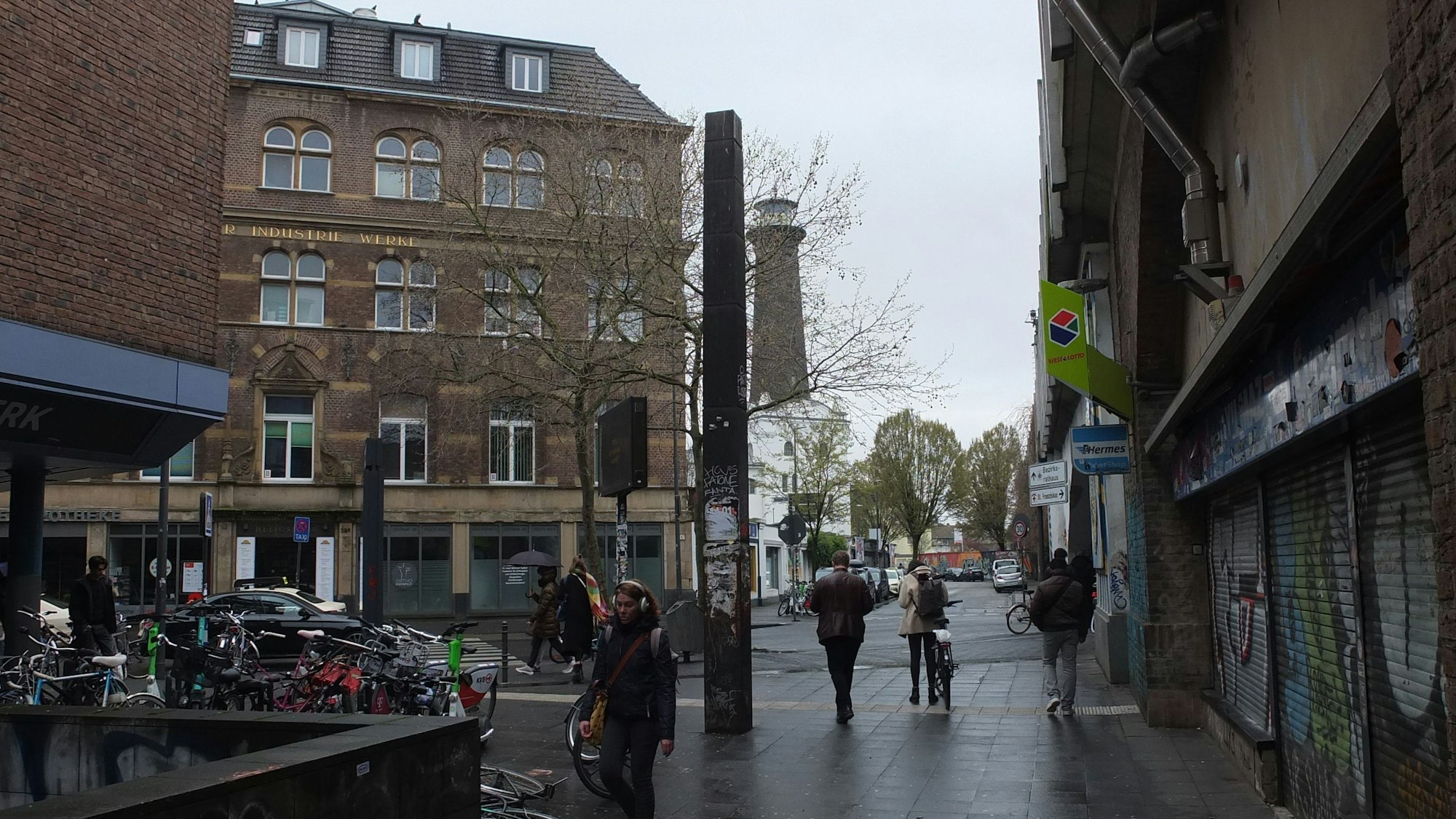 Die Stahlstele Streckung von Ansgar Nierhoff an der Venloer Straße umgeben von Häusern auf einem öffentlichen Platz.
