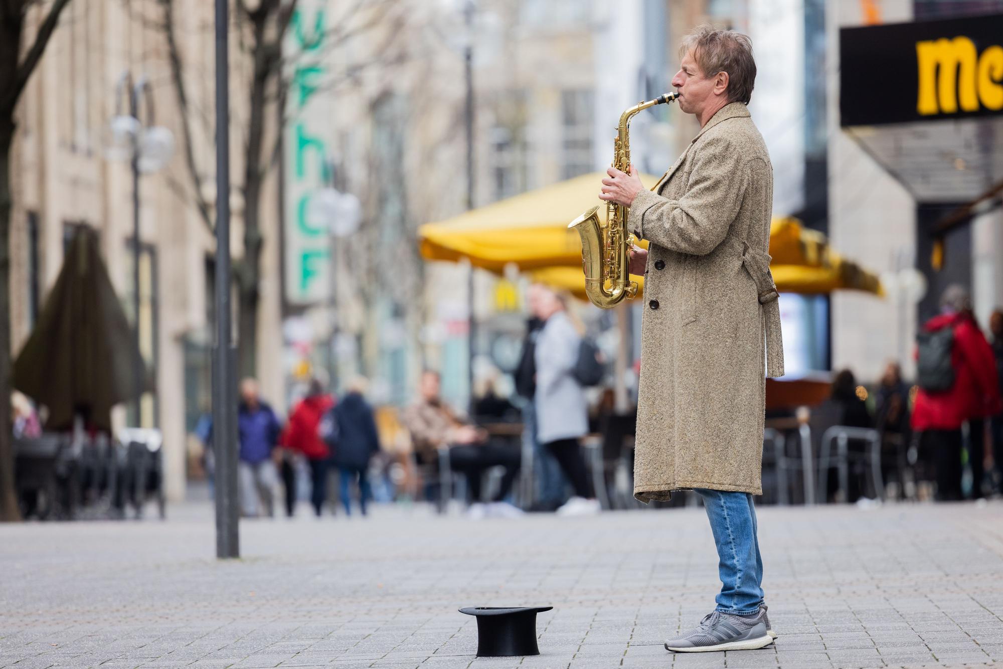 Ingolf Lück spielt in der Innenstadt Saxofon.