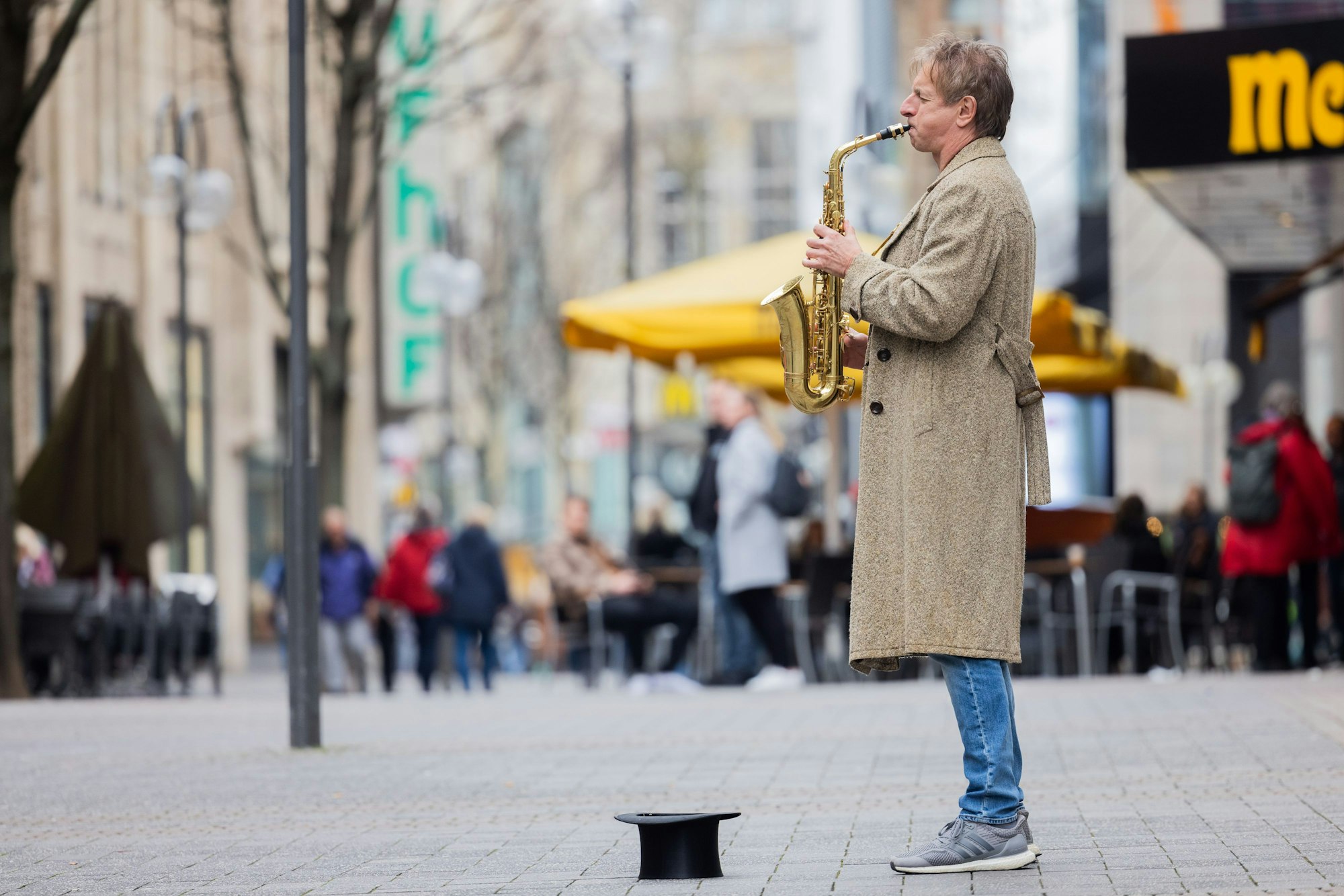 Ingolf Lück spielt in der Innenstadt Saxofon.