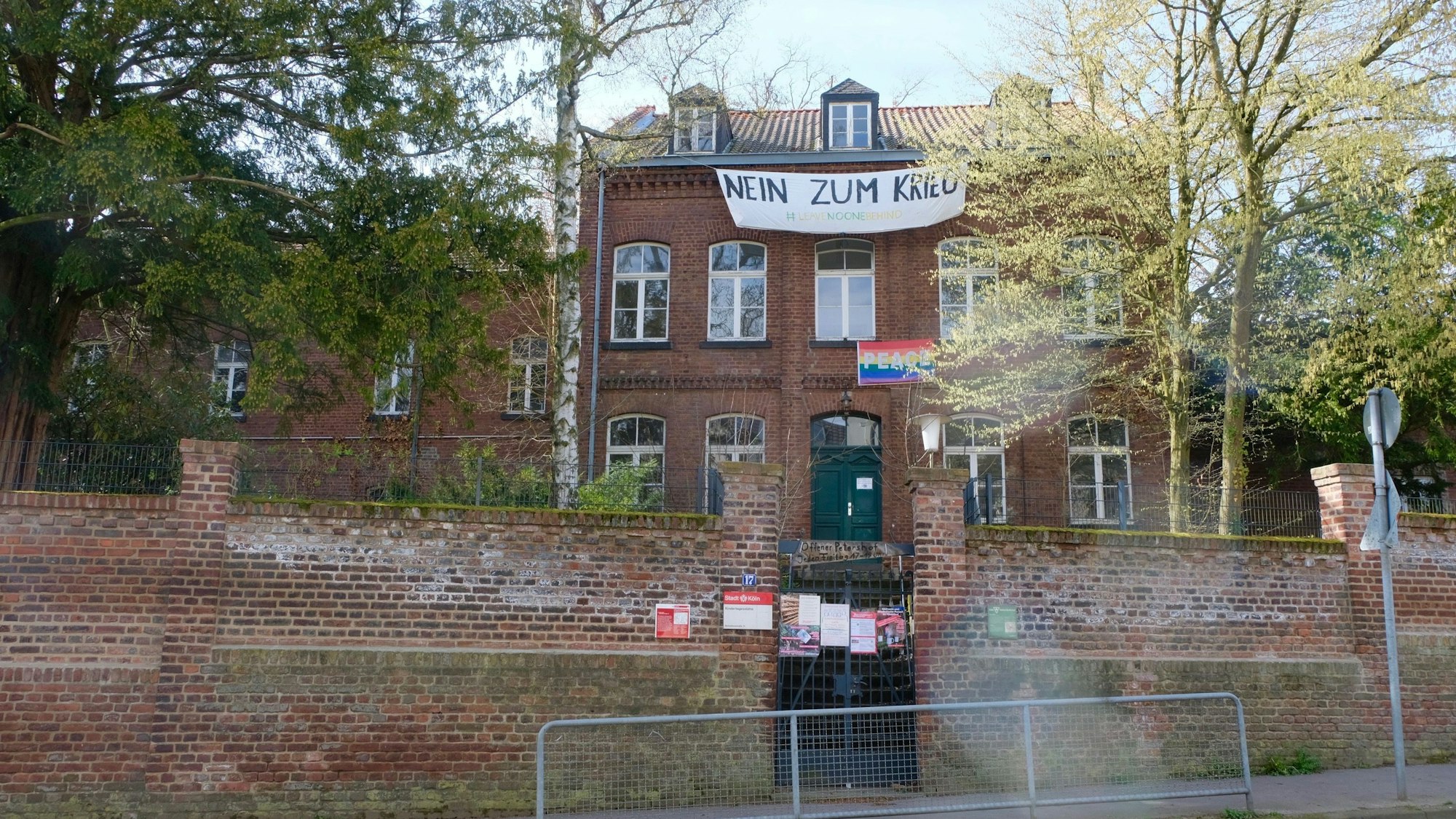 Der Petershof von außen mit einem Banner „Nein zum Krieg“.