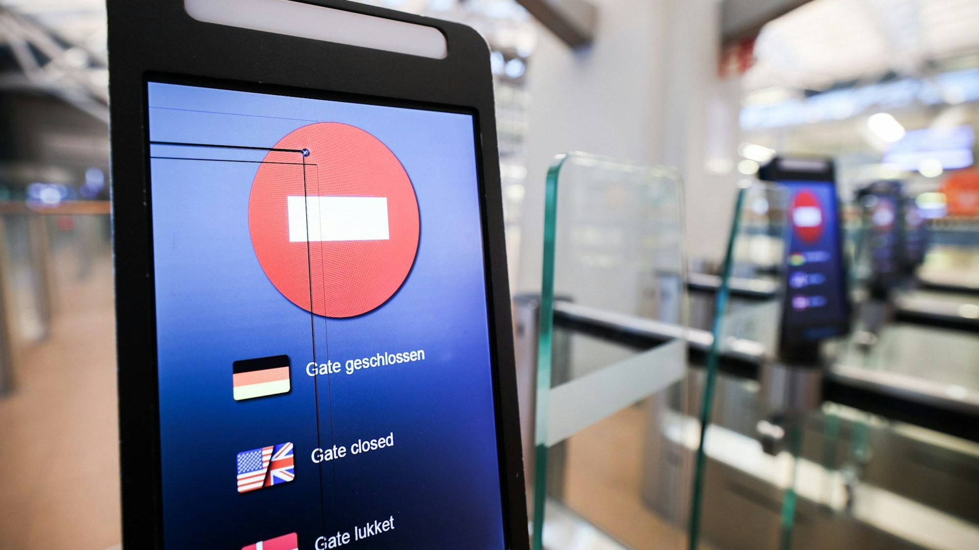 Auf einem Display am Eingang zur geschlossenen und menschenleeren Sicherheitskontrolle im Flughafen ·Gate geschlossen· zu lesen.