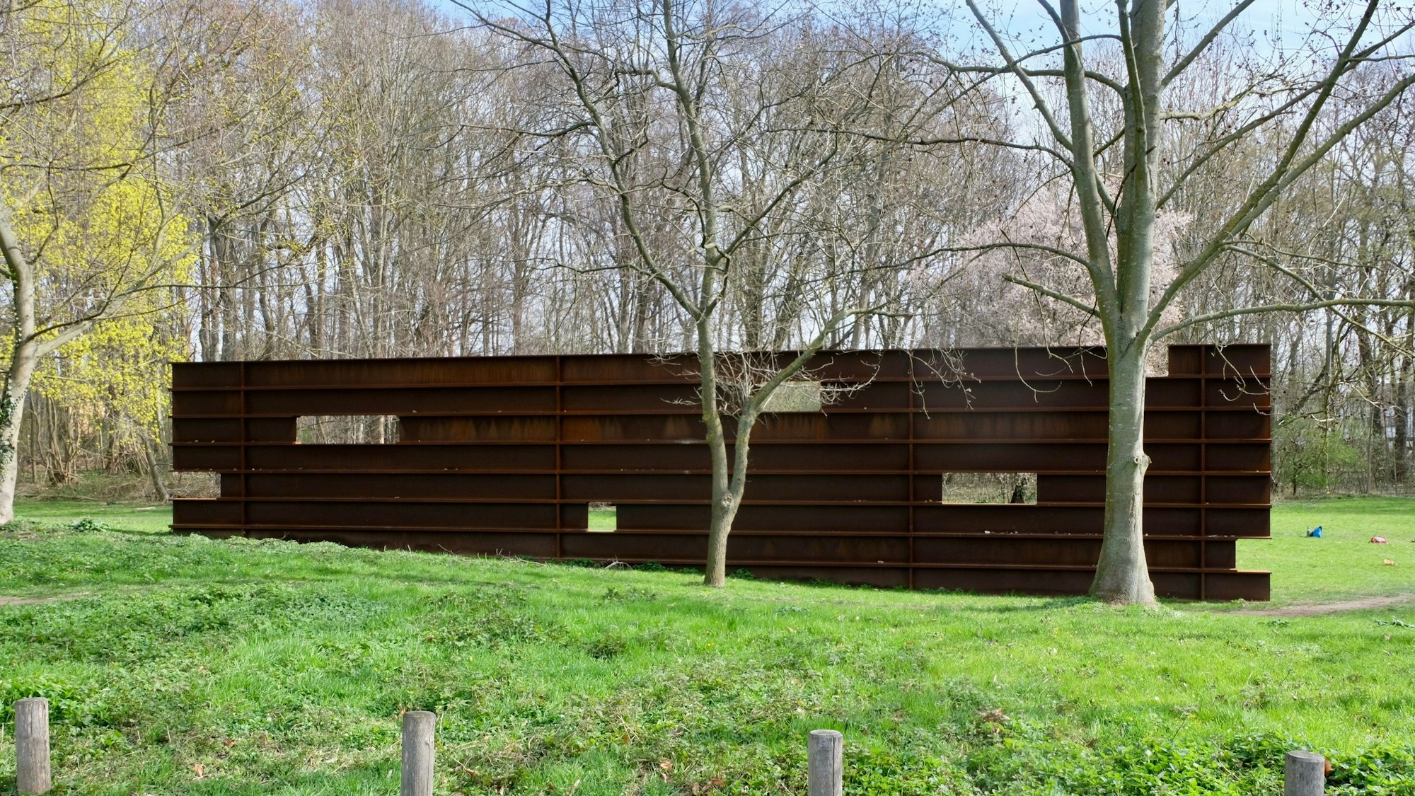 Die Cortenstahlwand in Müngersdorf auf einer grünen Wiese.