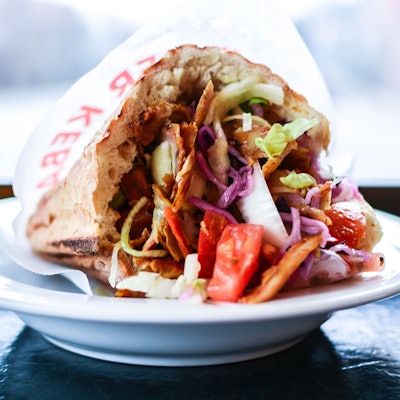 Eine Dönertasche liegt auf einem Teller.