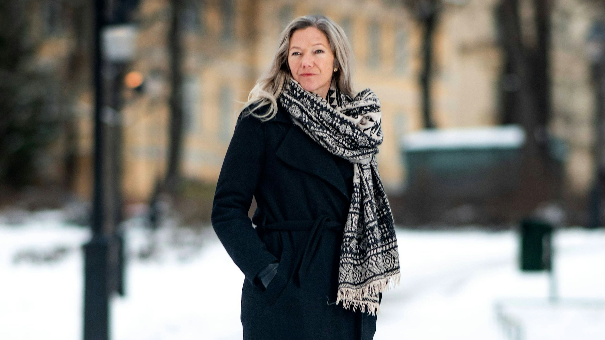 Die norwegische Autorin Maja Lunde mit Schal vor einem Haus und Bäumen im Schnee.