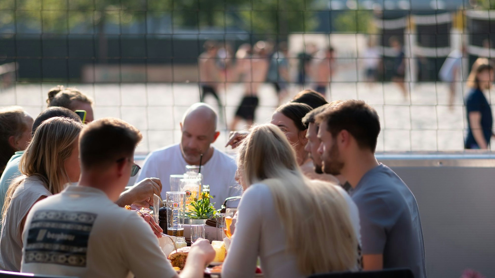 Eine Gruppe von Menschen sitzt an einem tisch und isst und trinkt zusammen.