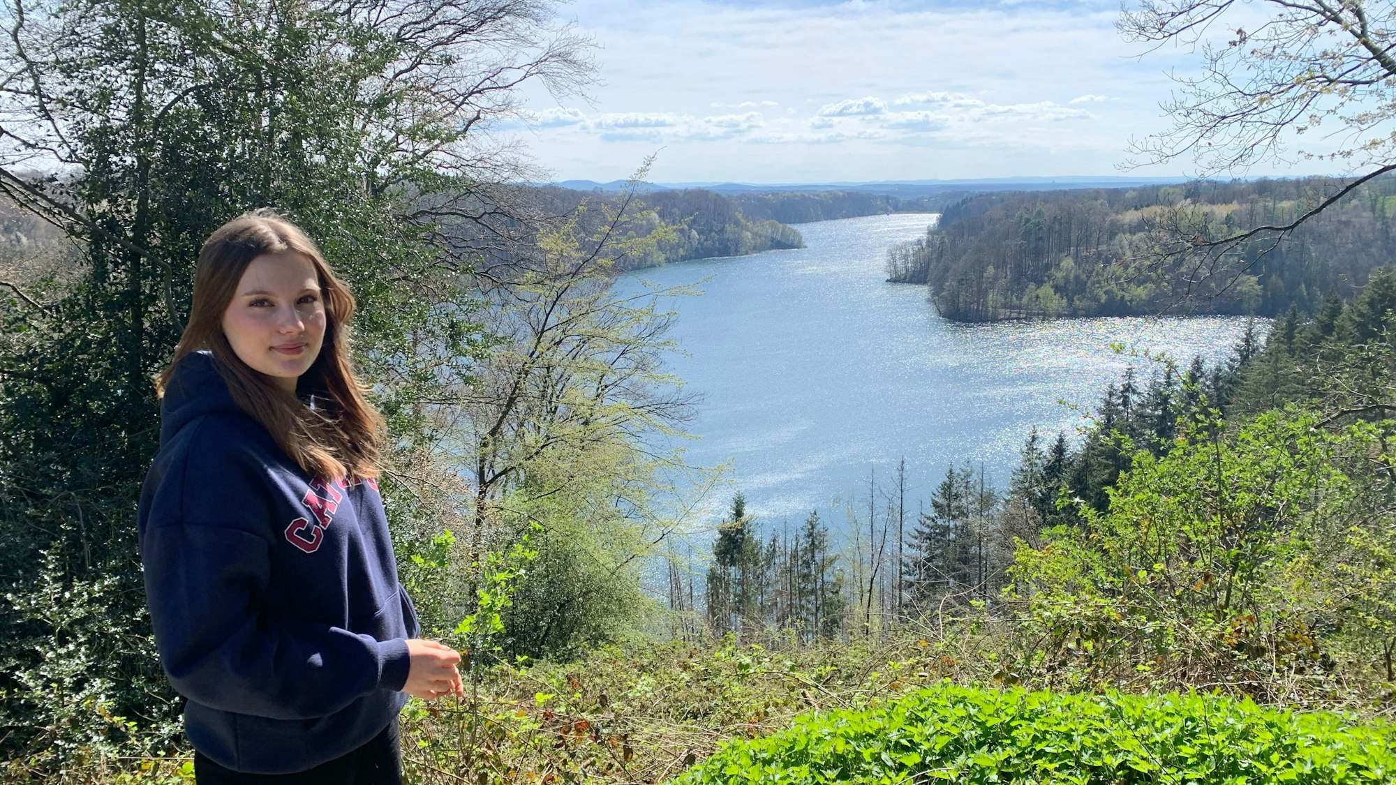 Eine junge Frau seht an der Wahnbachtalsperre.