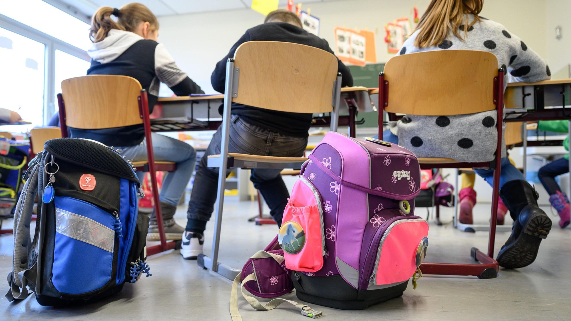 Schulranzen stehen in einer Grundschule.