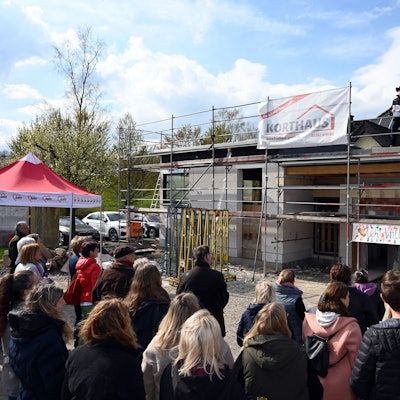 Am Rohbau der Erweiterung in Oberbantenberg feiern viele Menschen.