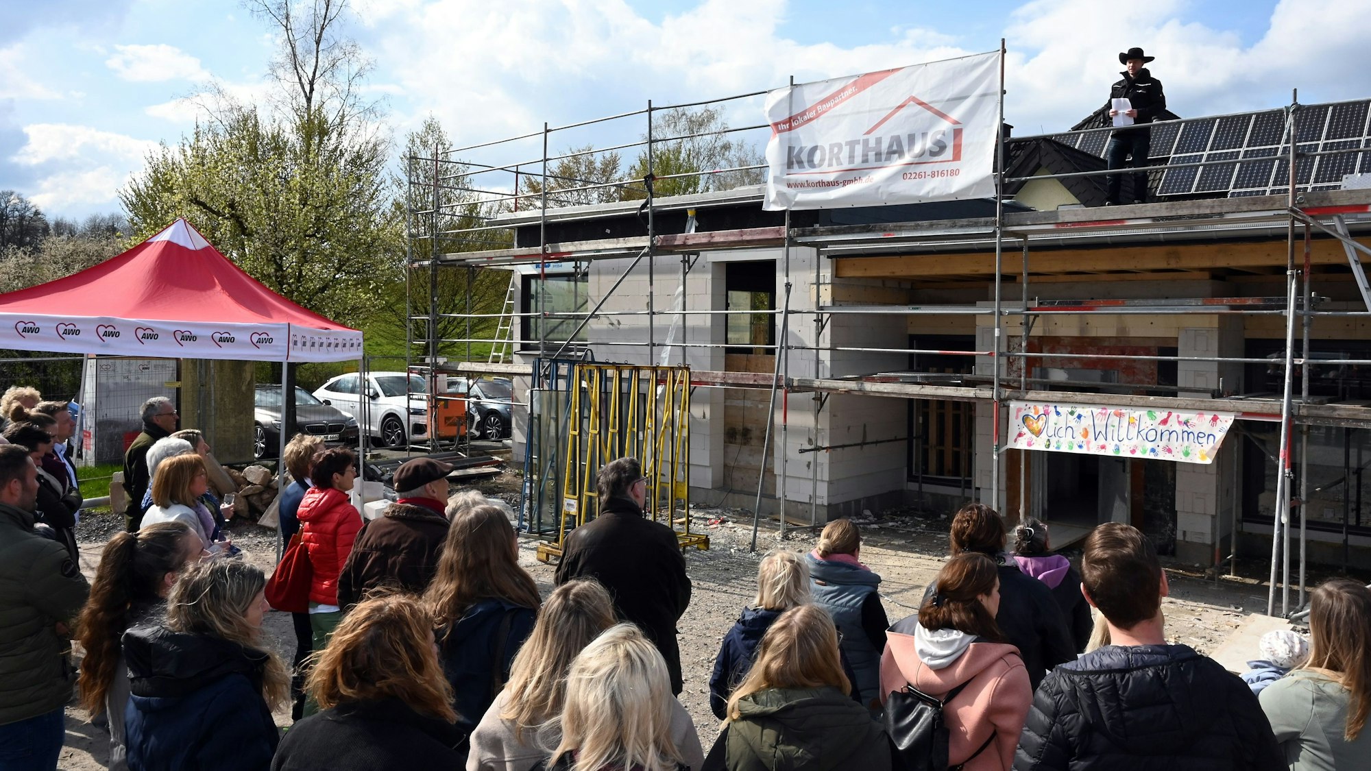 Am Rohbau der Erweiterung in Oberbantenberg feiern viele Menschen.