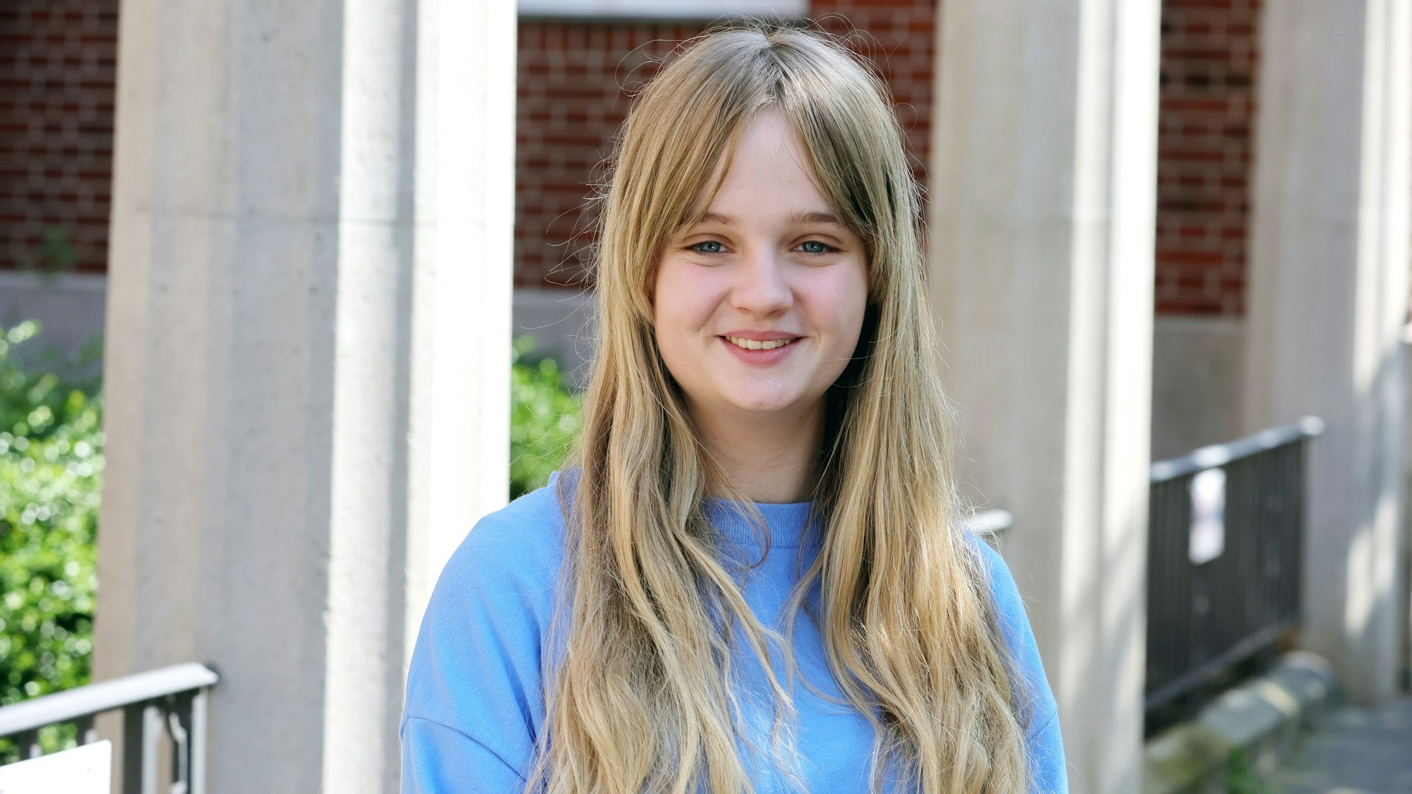 Eine Schülerin steht vor dem Schiller-Gymnasium nach ihrer Abi-Klausur.