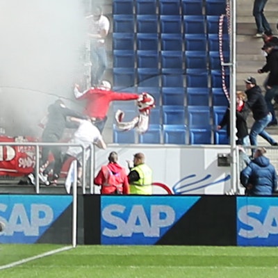 Ein als Kölner verkleidetere Gladbach-Fan reicht das Banner weiter.