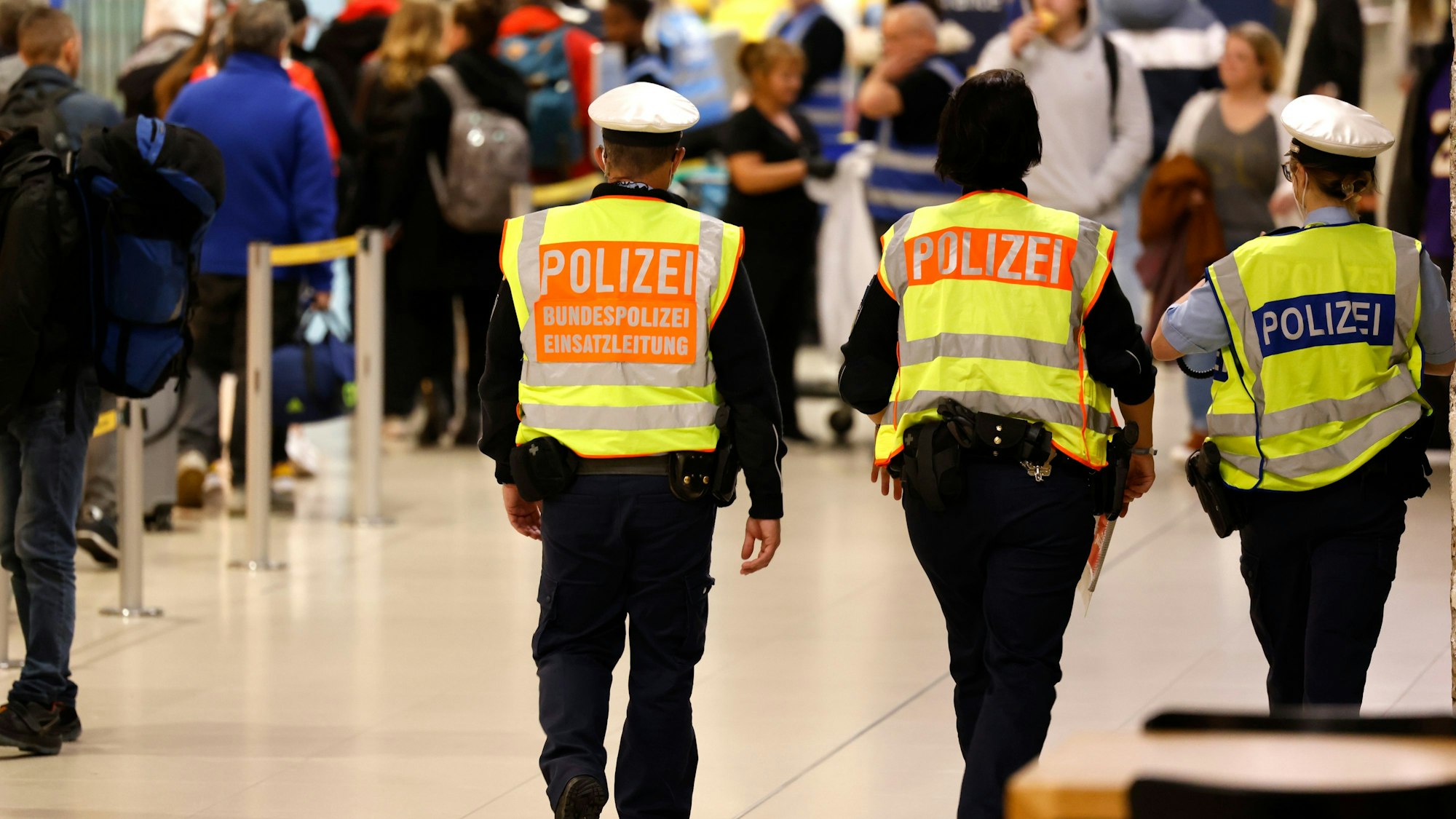 Drei Bundespolizisten laufen durch den Fliughafen Köln/Bonn