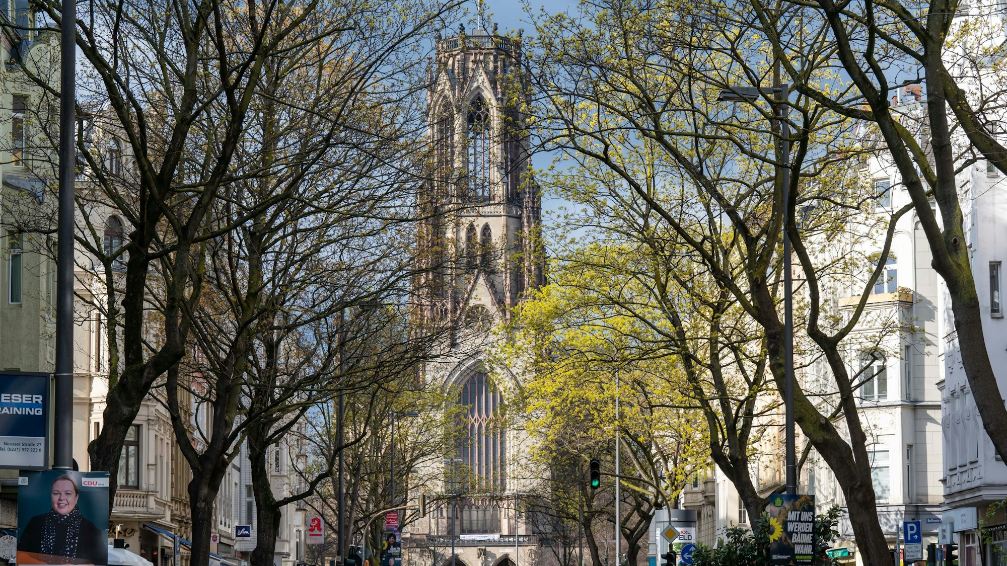 Blick auf die Agnes-Kirche und die Baumallee an der Neusser Straße im Agnesviertel