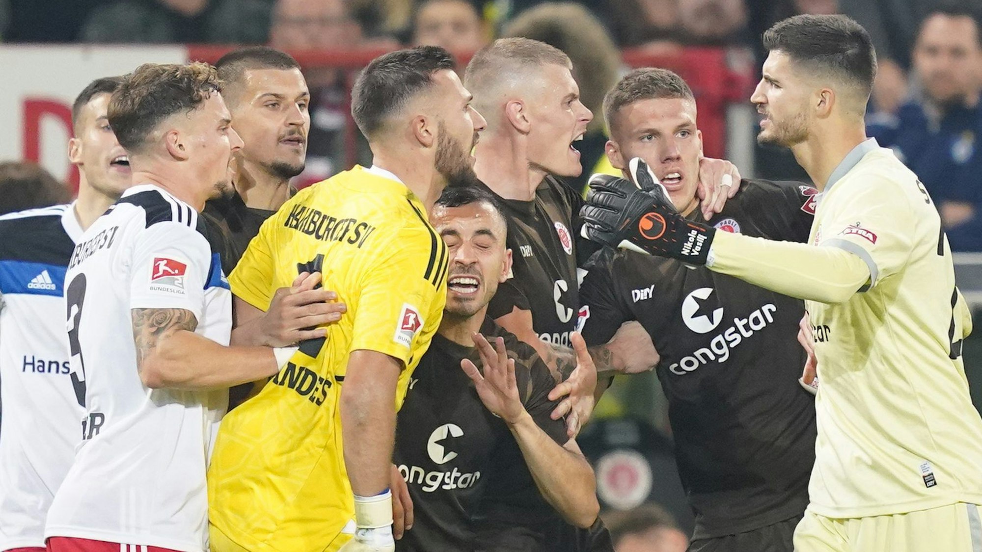 Spieler von St. Pauli und Hamburger SV in einer hitzigen Situation.