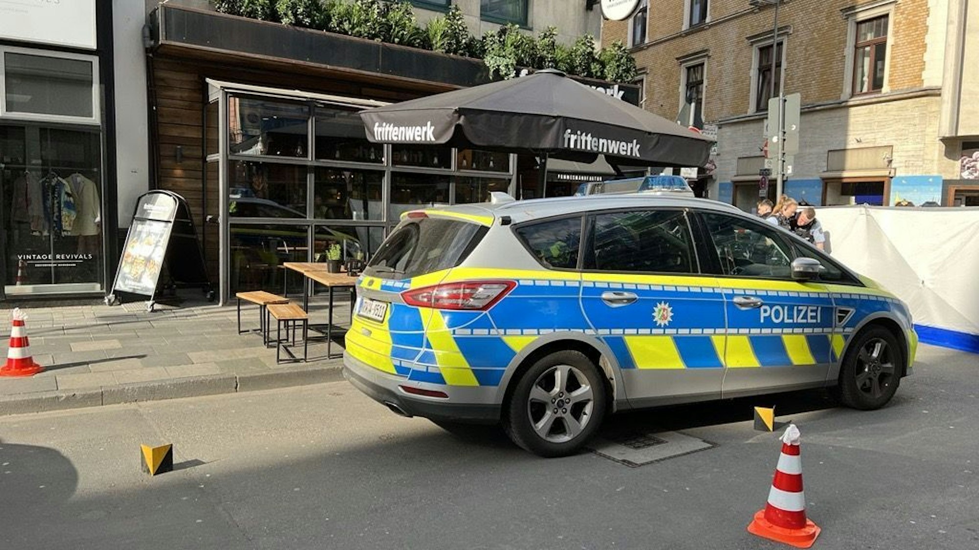 Ein Polizeiauto steht vor der Imbissbude „Frittenwerk“ in der Kölner Ehrenstraße.