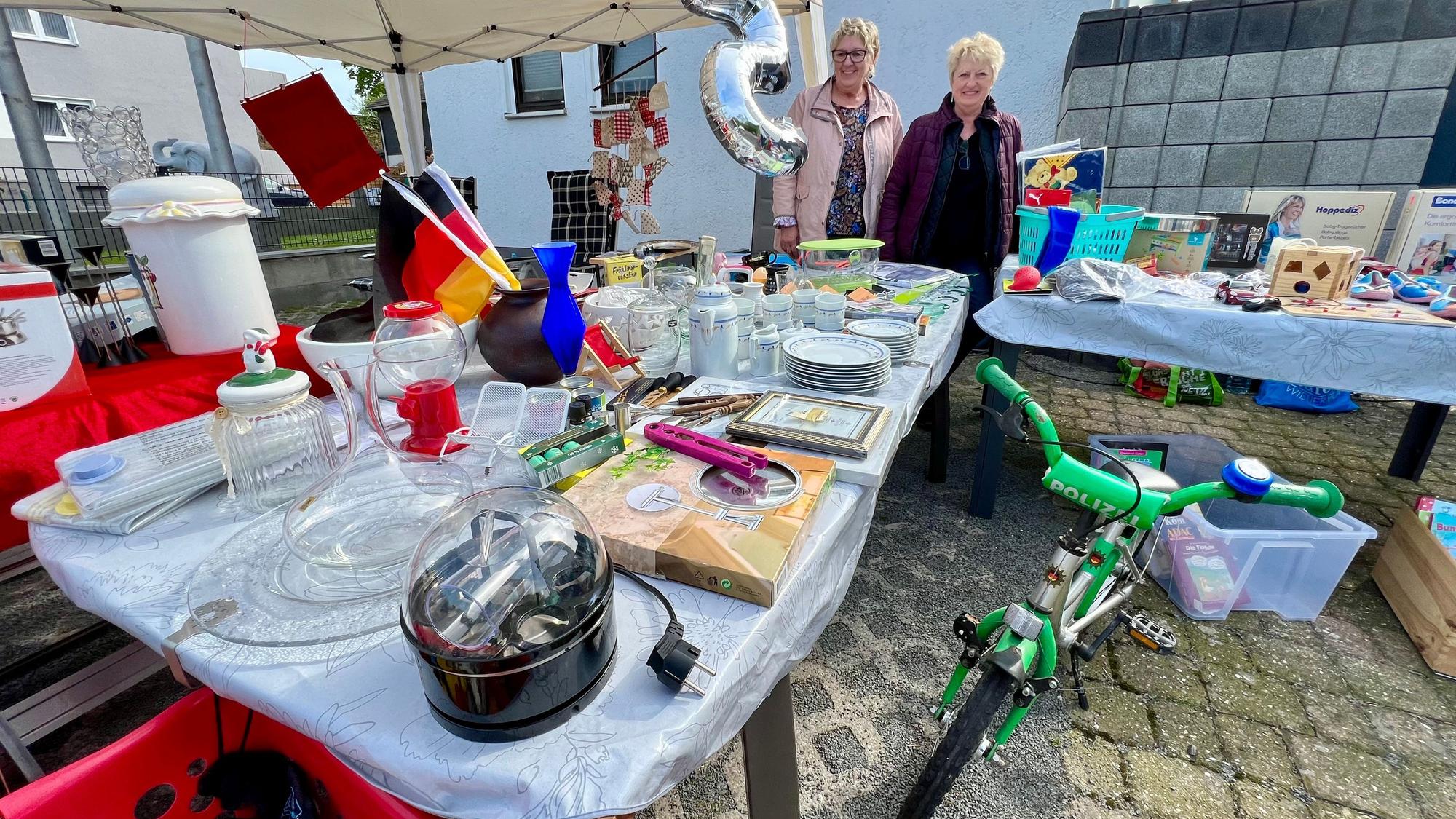 Birgit Faber und Angelika Schmitz an einem Tisch mit Trödel am Bendenweg in Bürrig.