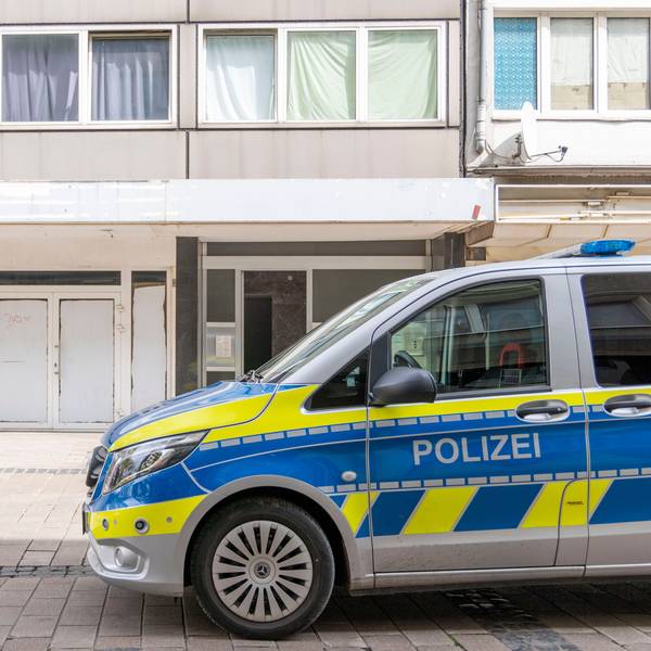 Ein Polizeiwagen steht vor dem Wohnhaus des Tatverdächtigen in der Duisburger Altstadt.