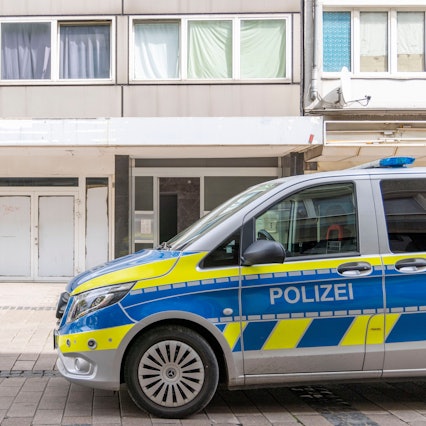 Ein Polizeiwagen steht vor dem Wohnhaus des Tatverdächtigen in der Duisburger Altstadt.