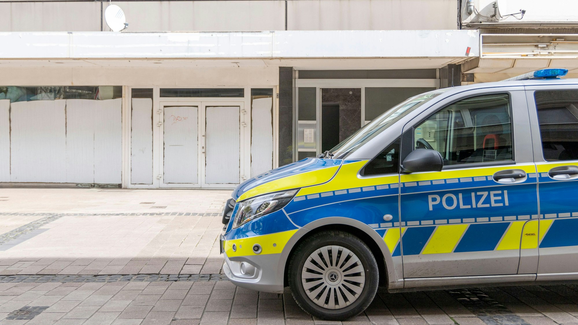 Ein Polizeiwagen steht vor dem Wohnhaus des Tatverdächtigen in der Duisburger Altstadt.