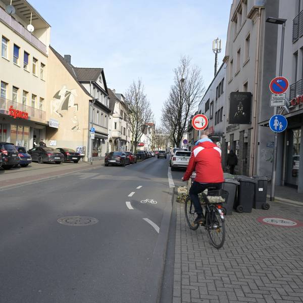 Ein Fahrradfahrer fährt von einem endenden Radweg auf die Straße.