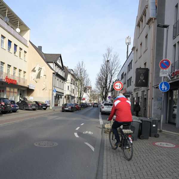 Ein Fahrradfahrer fährt von einem endenden Radweg auf die Straße.