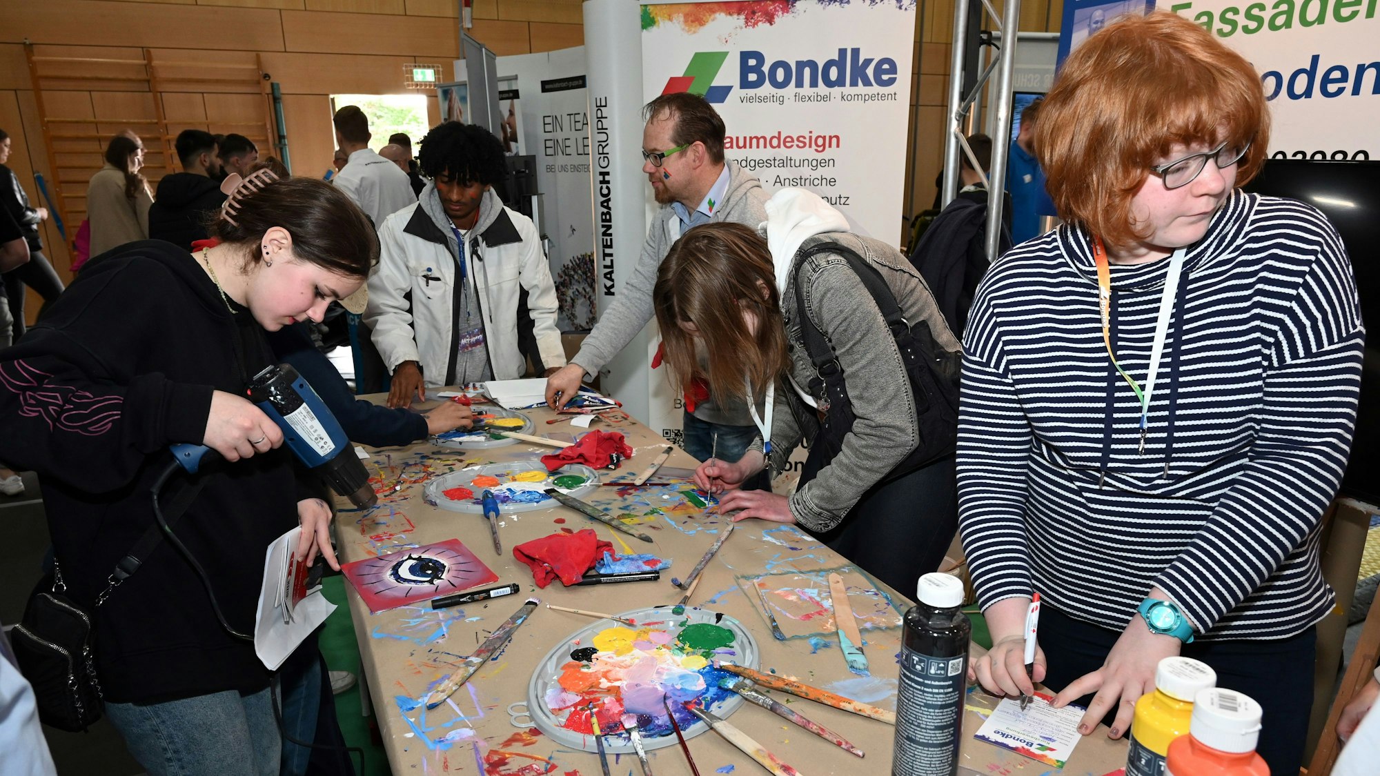 Junge Menschen an einem Stand bei der Ausbildungsmesse in der Sporthalle "Auf dem Bursten" in Bergneustadt.