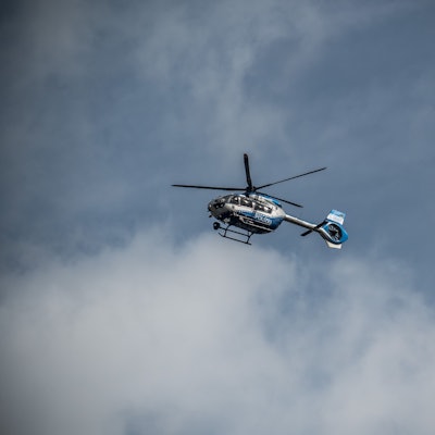 Ein Polizeihubschrauber mit fünfblättrigen Rotor fliegt über Leverkusen.