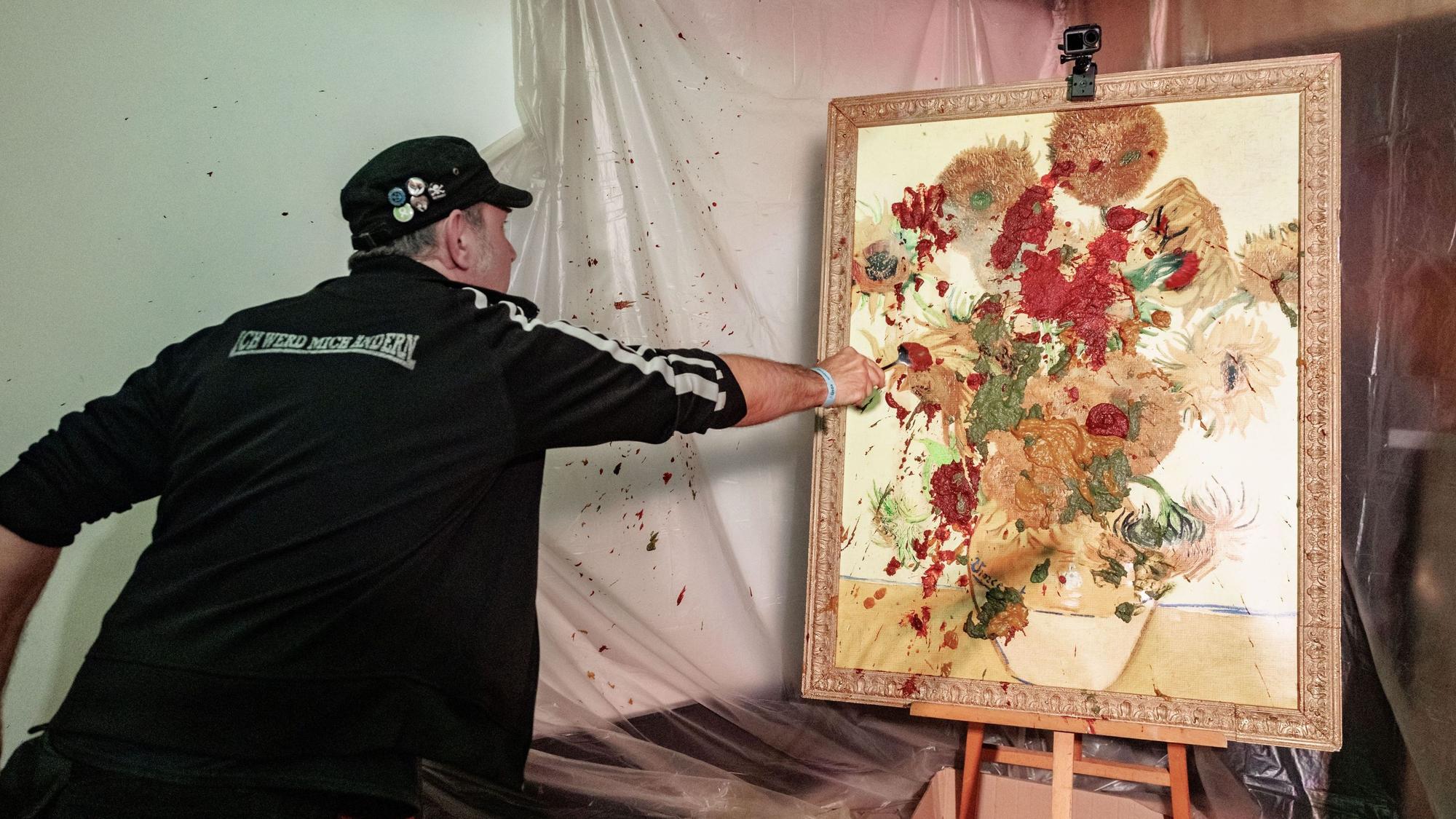 TV-Koch Ole Plogstedt wirft im St. Pauli Museum Brei auf ein Bild.