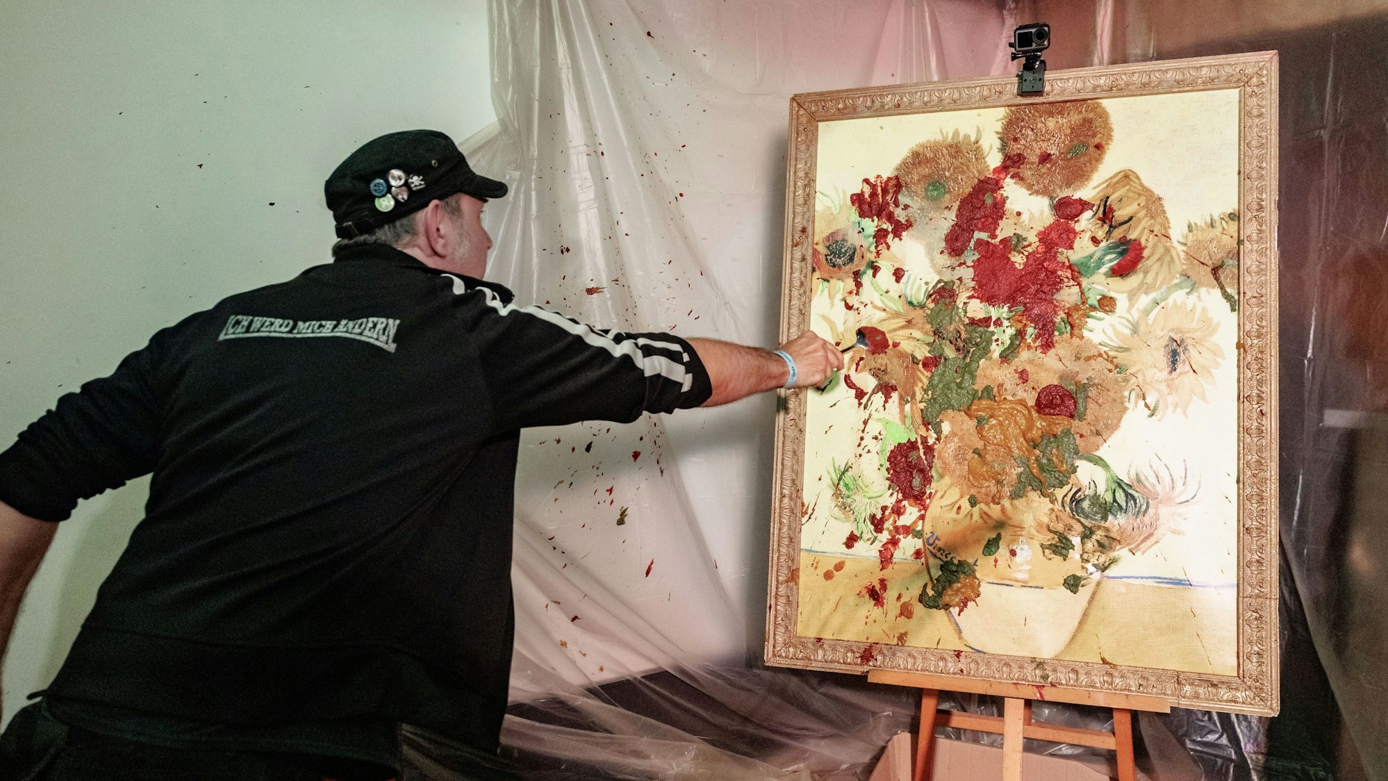 TV-Koch Ole Plogstedt wirft im St. Pauli Museum Brei auf ein Bild.