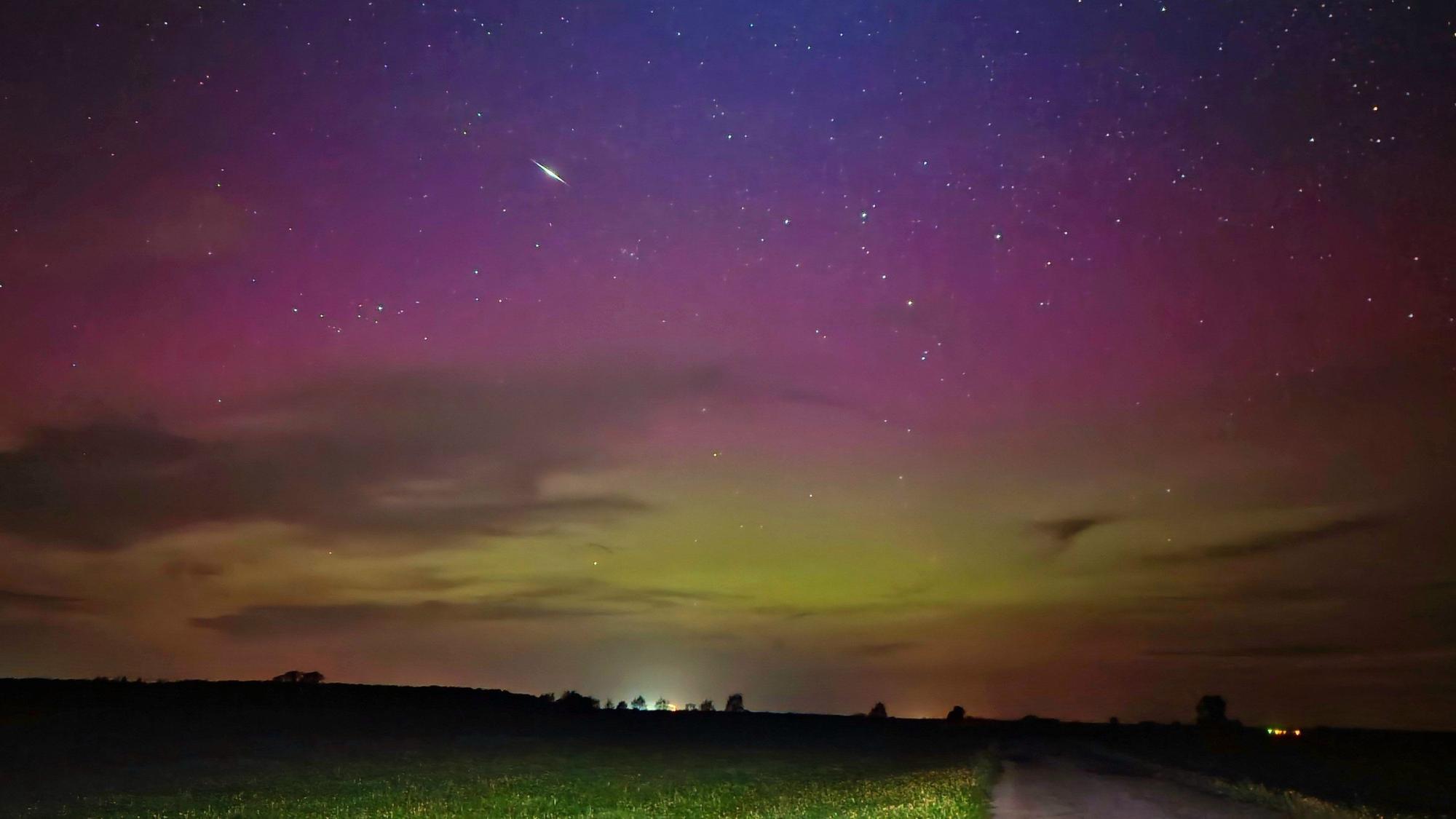 Ein Himmelskörper zieht durch die Polarlichter am nächtlichen Himmel. Das Bild wurde in Fischbeck, Sachsen-Anhalt aufgenommen.