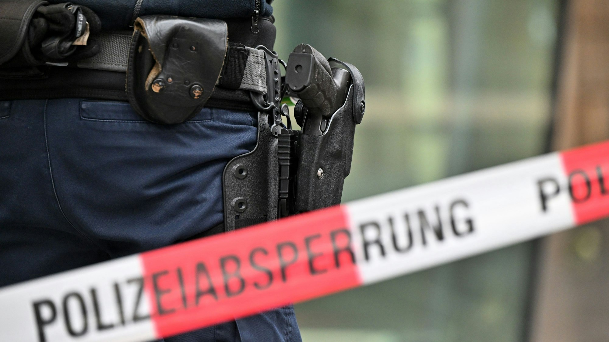 Bewaffnete Bundespolizisten stehen an einer Polizeiabsperrung.
