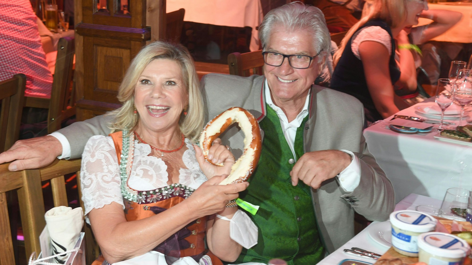 Marianne und Michael Hartl mit Brezel in der Hand an einem Tisch.