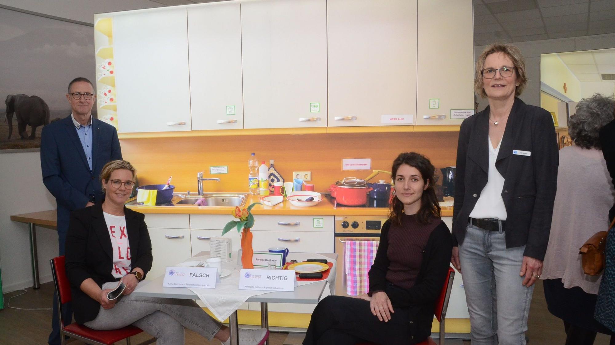 Vier Menschen in einer Musterwohnung für Demenzkranke.