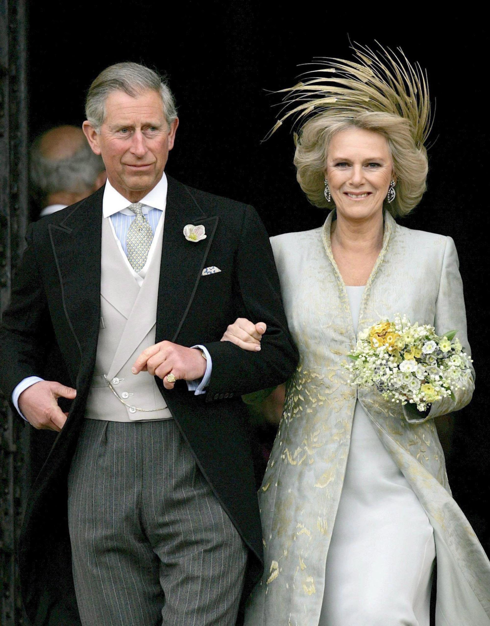 Prinz Charles hat seine Camilla, die ein cremefarbenes Seidenchiffonkleid trägt, im Arm.