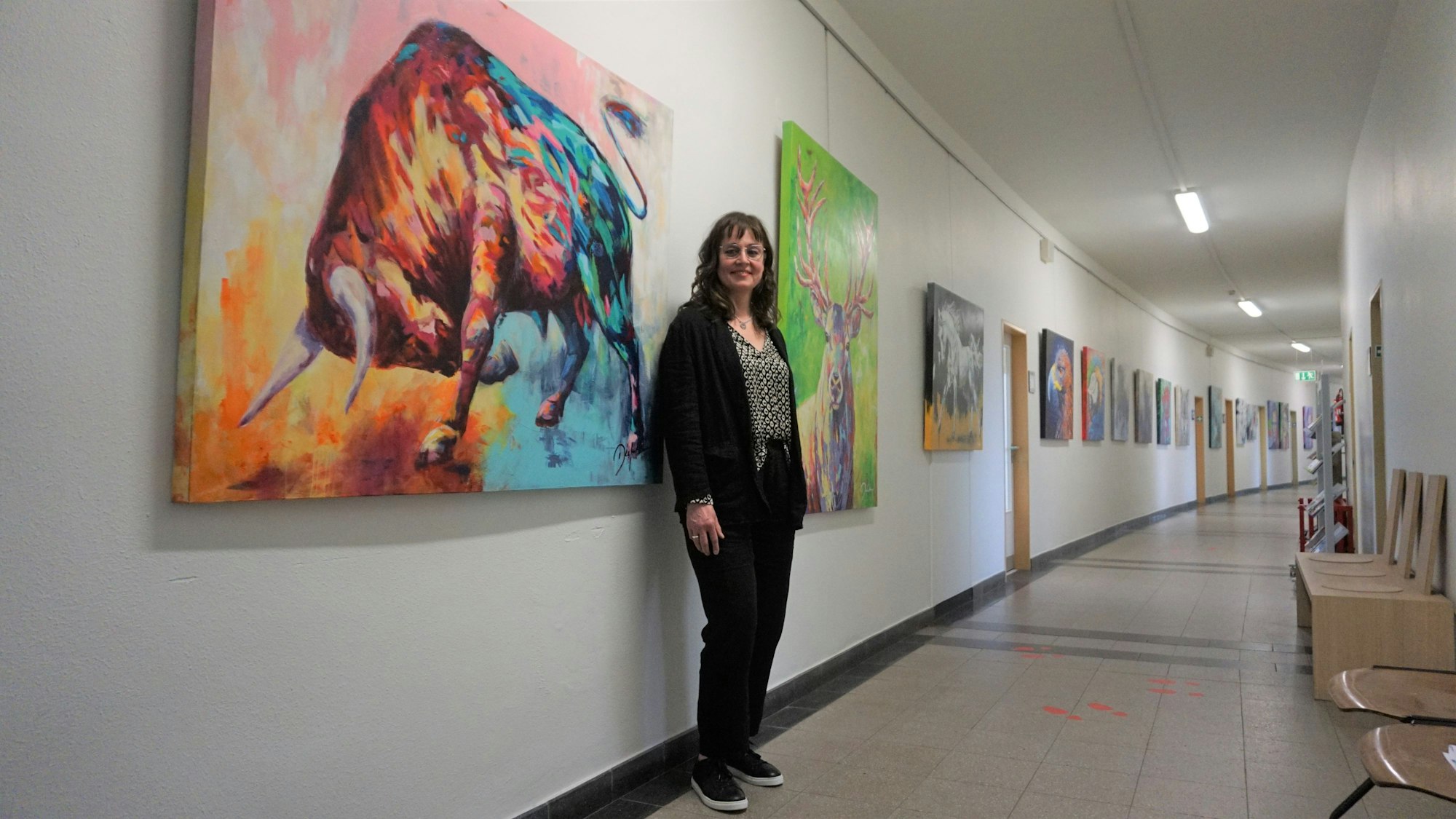 Birgit Diefenthal steht vor einer Reihe ihrer Bilder im Euskirchener Rathaus.