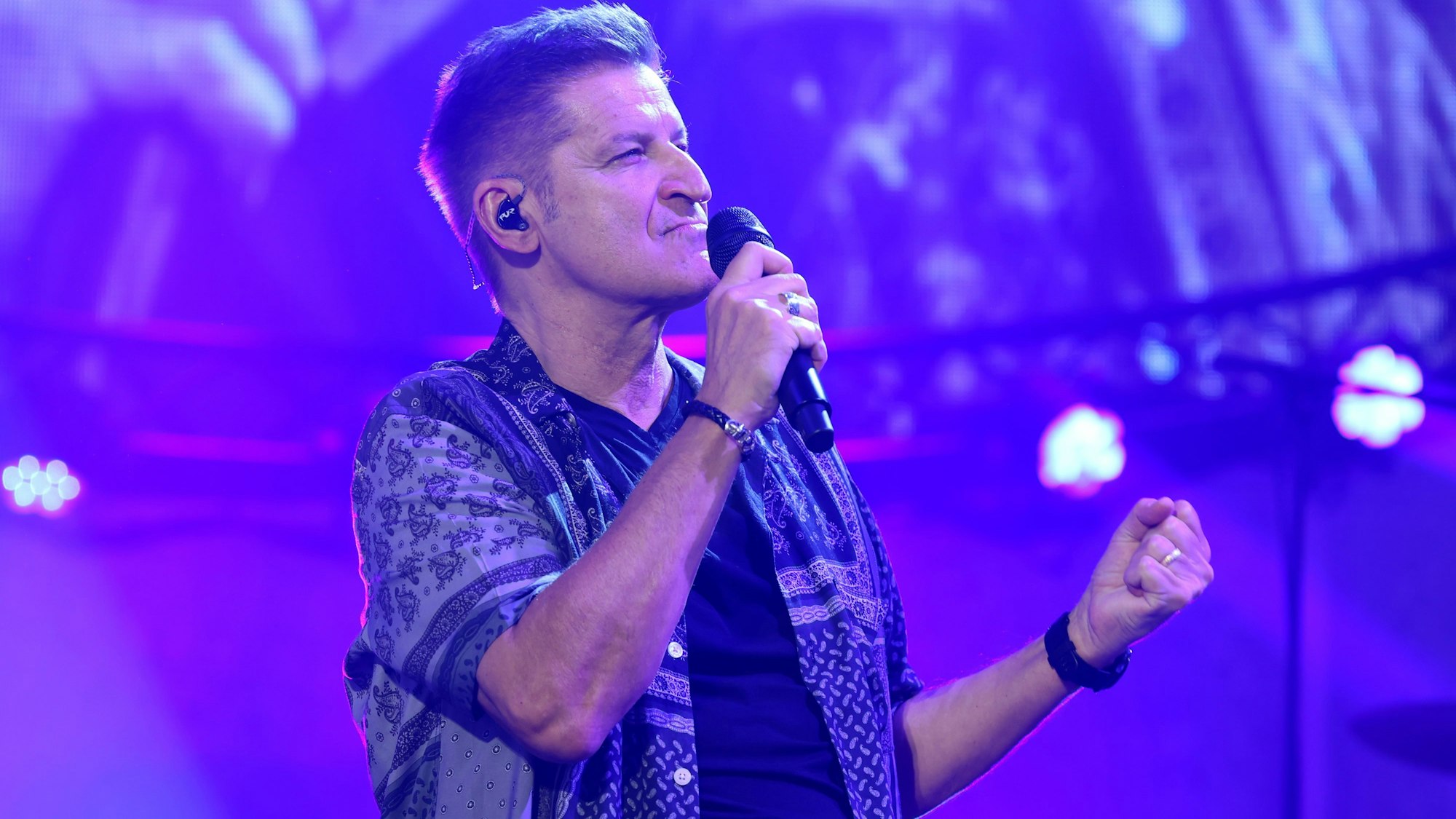 Hartmut Engler singt ins Mikrophon.