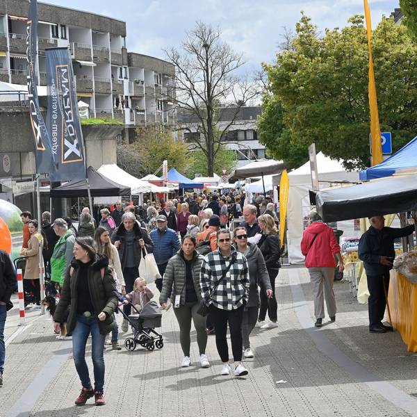 Viele Menschen flanieren über die Straße, am Straßenrand sind Verkaufsbuden aufgestellt.