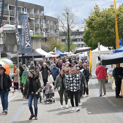 Viele Menschen flanieren über die Straße, am Straßenrand sind Verkaufsbuden aufgestellt.