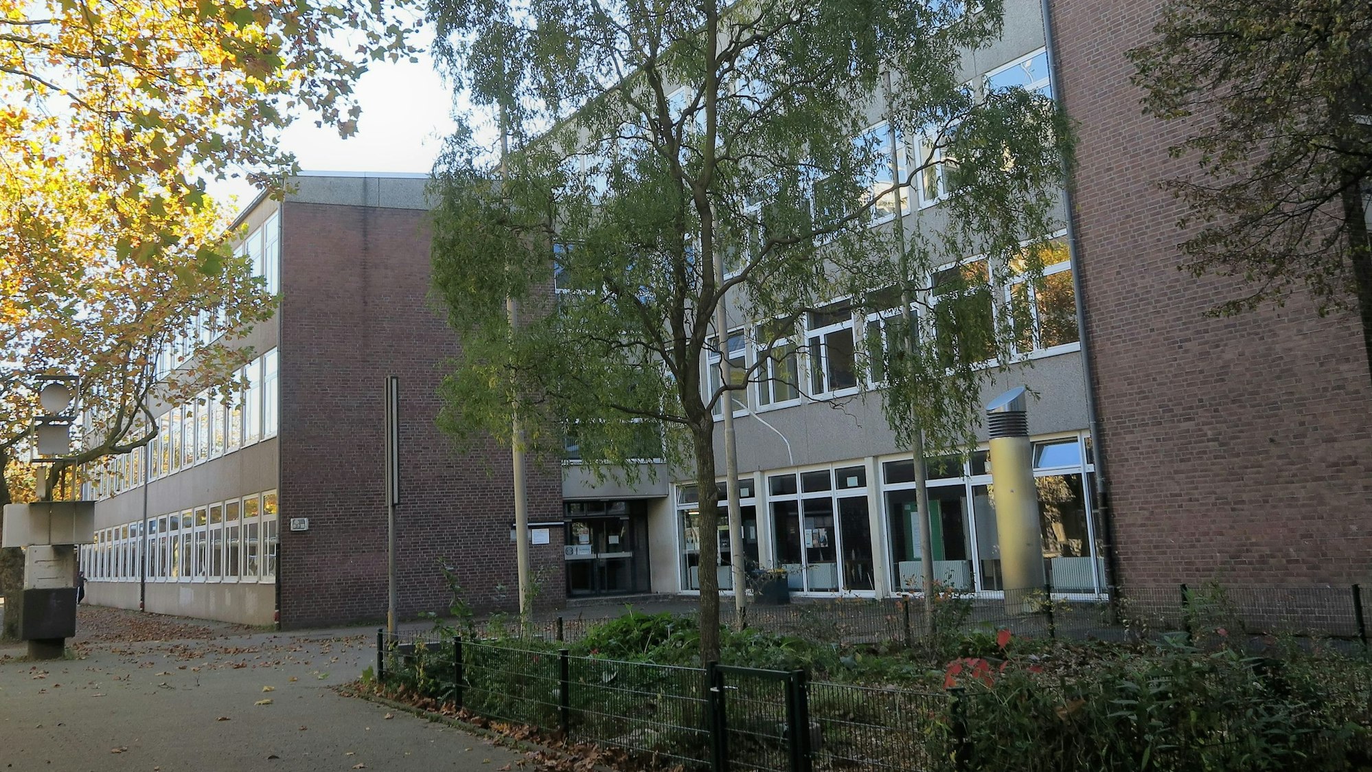 Ein Schulgebäude mit Bäumen von außen.