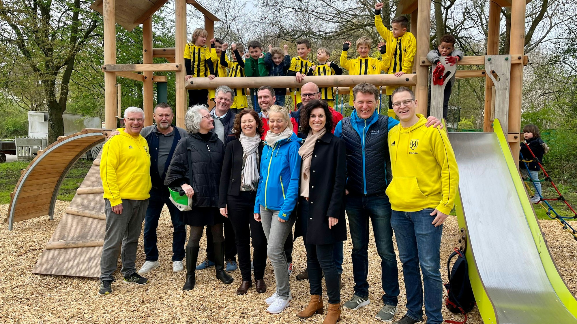Verantwortliche von Verein, Sportpark und Sponsoren vor Kindern auf dem Spielgerüst.