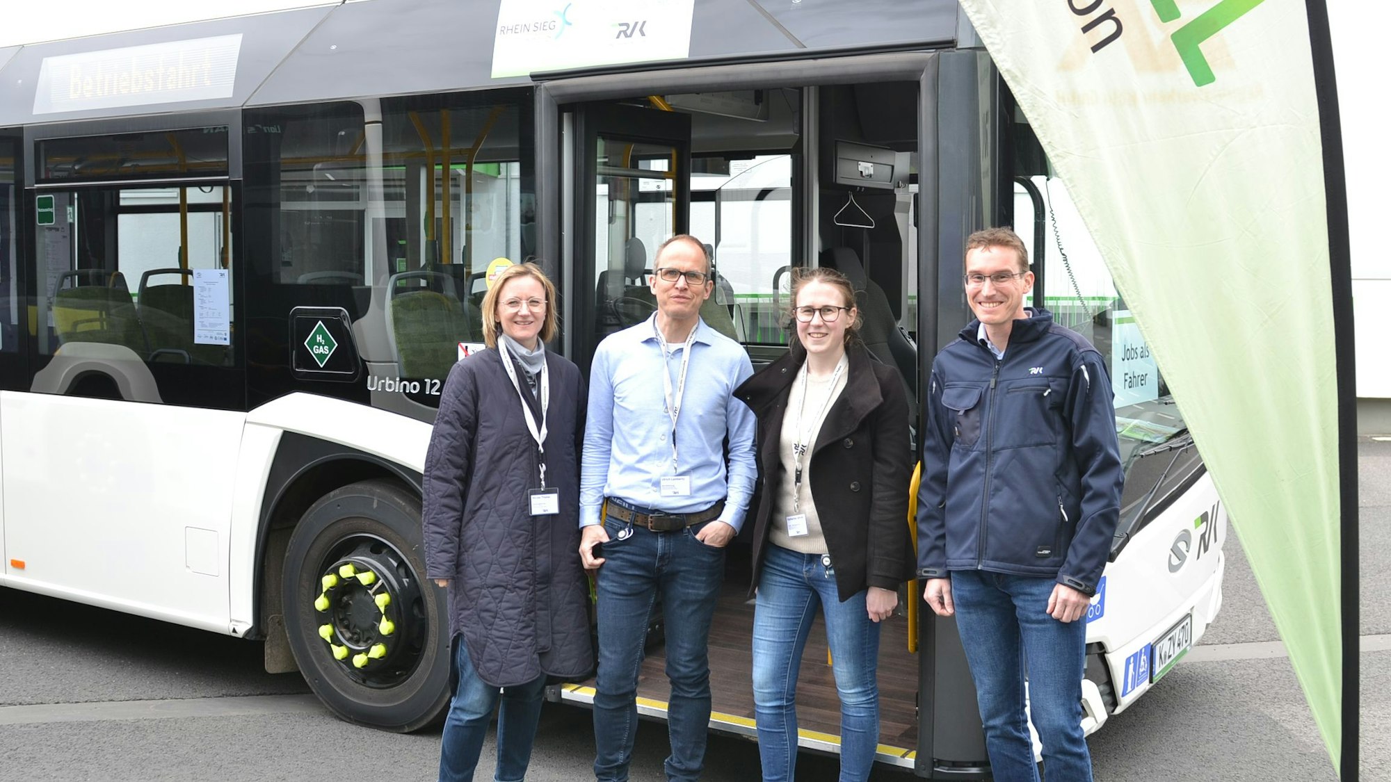 Mitarbeiter des RVK stehen vor einem ihrer Busse.