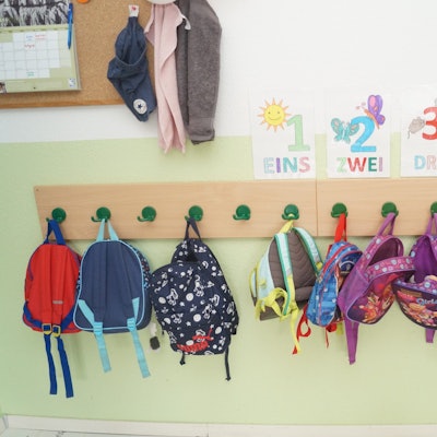 Rucksäcke hängen in einer Kita an einer Gaderobe. (Symbolbild)