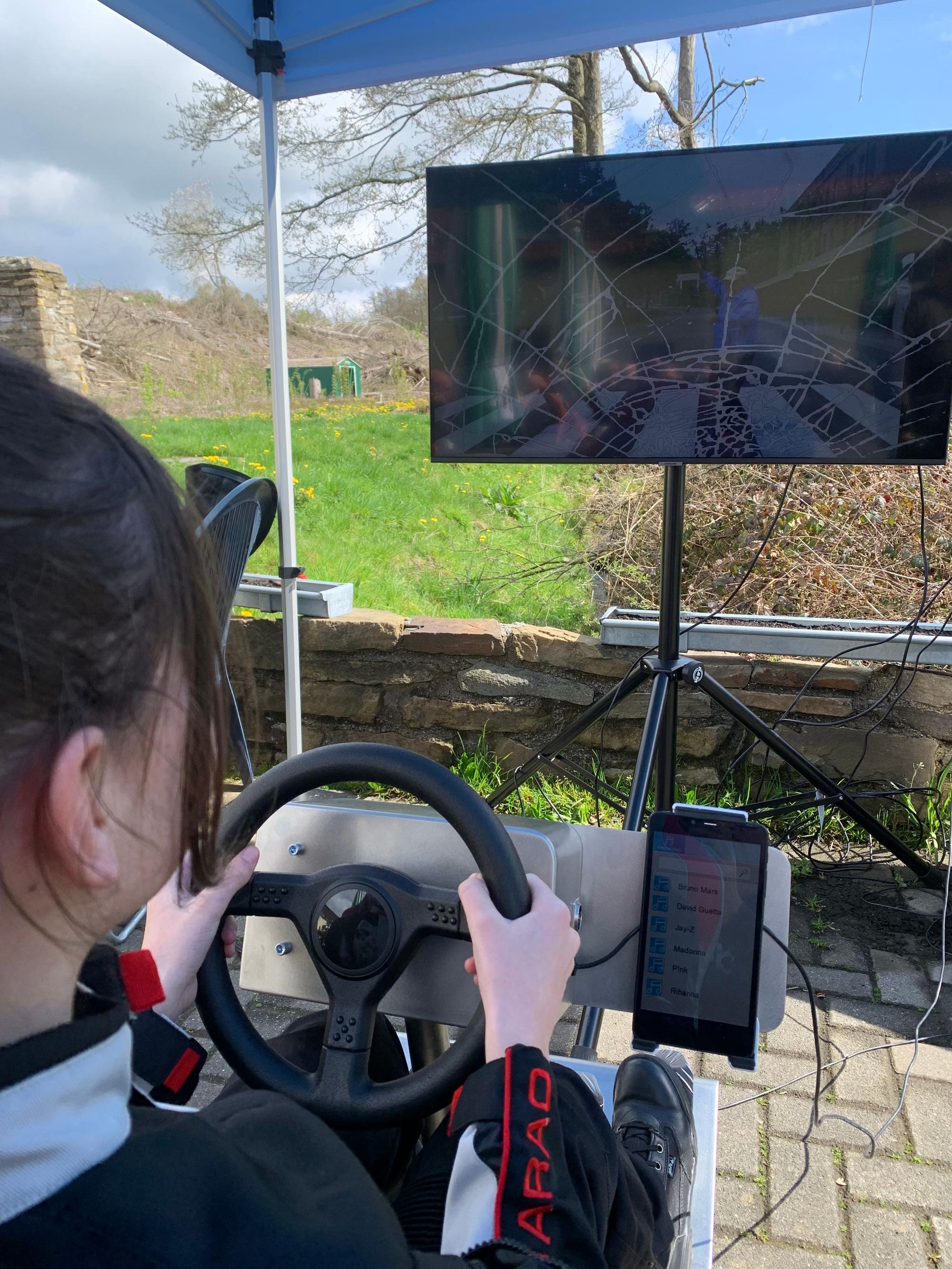 Ein Mädchen sitzt an einem Motorrad-Simulator.