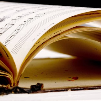 Zu sehen ist ein altes Notenheft mit handschriftlichen Noten.