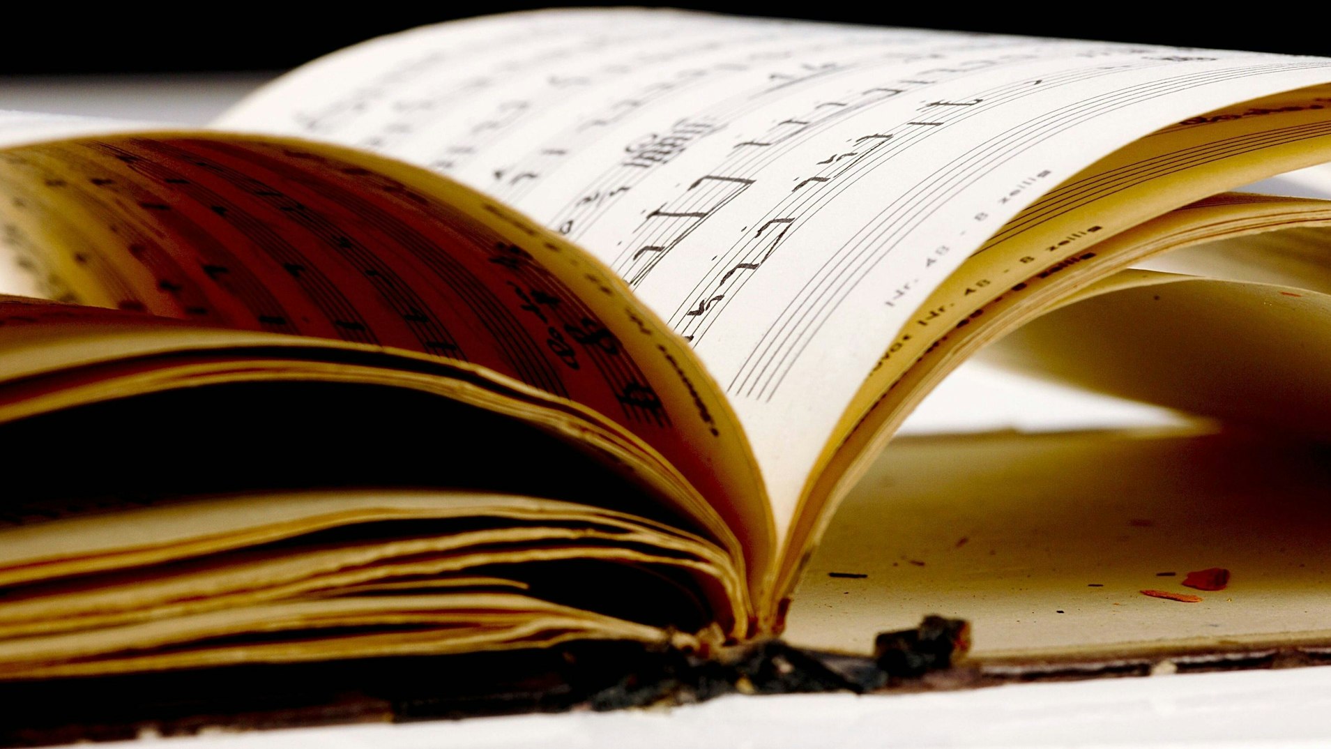 Zu sehen ist ein altes Notenheft mit handschriftlichen Noten.
