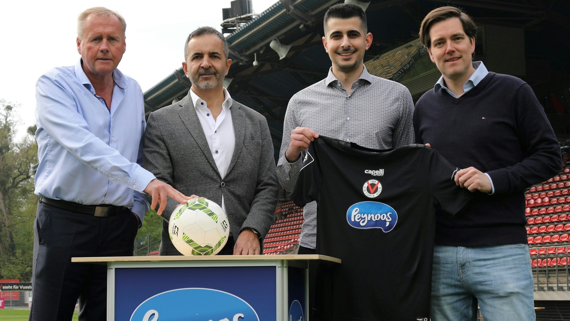 Eric Bock (v. links), Peynoos-Gründer und Geschäftsführer Hasan Dogan, Cem Dogan und Axel Freisewinkel mit einem schwarzen Viktoria-Trikot, das in der neuen Saison in dieser Grundfarbe das Ausweichtrikot sein wird.