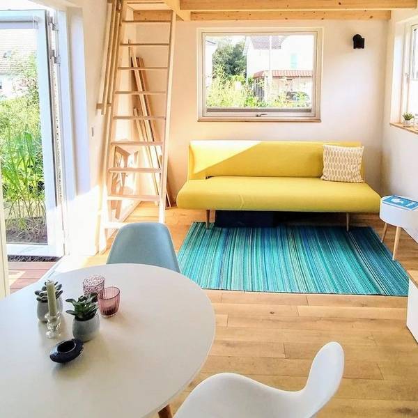 Blick auf eine Couch in einem Tiny House im Siebengebirge, das über Airbnb angeboten wird.