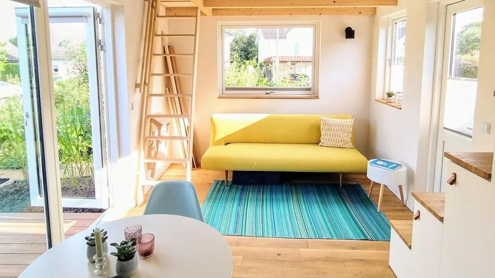 Blick auf eine Couch in einem Tiny House im Siebengebirge, das über Airbnb angeboten wird.
